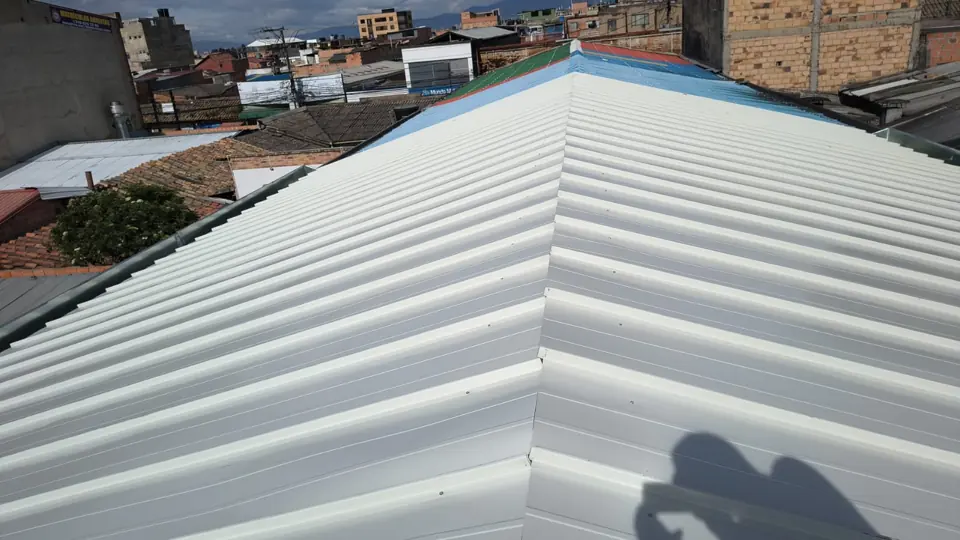Cubierta blanca a dos aguas con caballete en un barrio de Bogotá